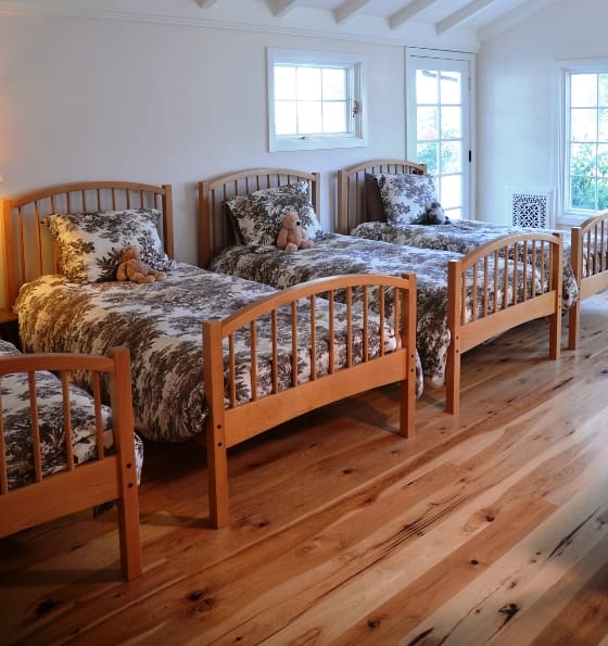 This California retreat's bunkhouse-style bedroom needed a wood floor that could accommodate heavy foot traffic, so the homeowners chose wide plank Hickory flooring. 