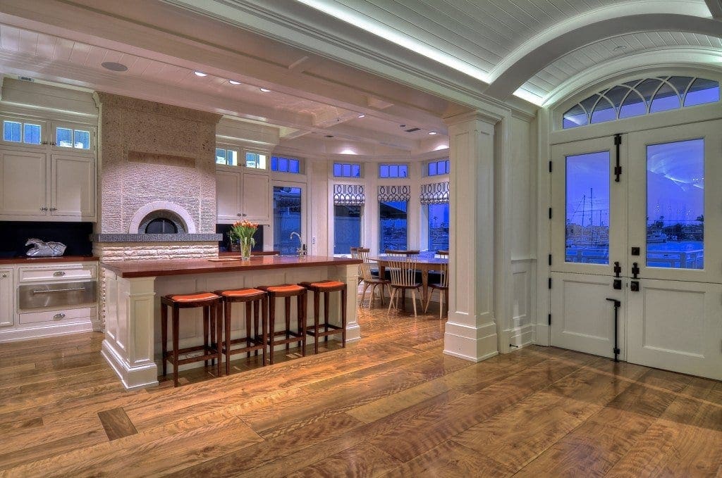 figured grain of curly birch wood flooring adds interest to a white kitchen