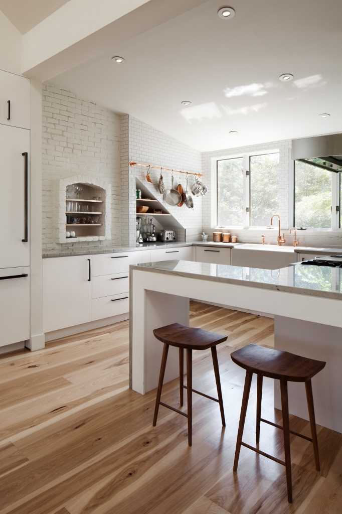 Warming up a white kitchen with a variegated wood floor.